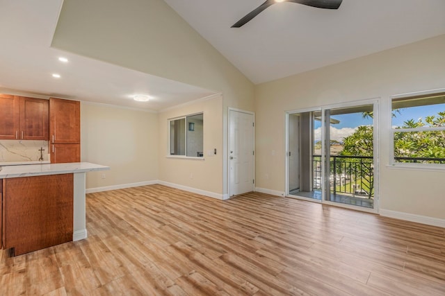 kitchen featuring backsplash, ceiling fan, light hardwood / wood-style flooring, and high vaulted ceiling