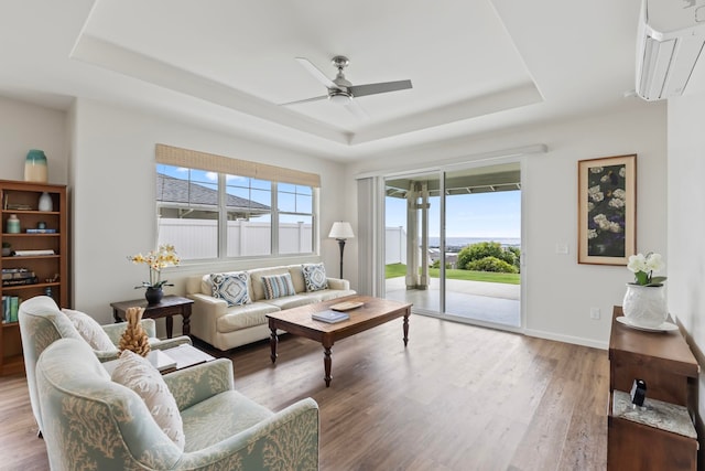 115 Nanu Pl, Wailuku, HI 96793 - living room with a tray ceiling, a wall mounted air conditioner, a ceiling fan, and wood finished floors