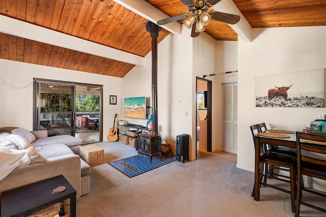 carpeted living room featuring high vaulted ceiling, a wood stove, ceiling fan, wooden ceiling, and beam ceiling