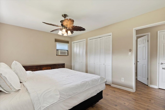 bedroom with multiple closets, ceiling fan, and hardwood / wood-style floors