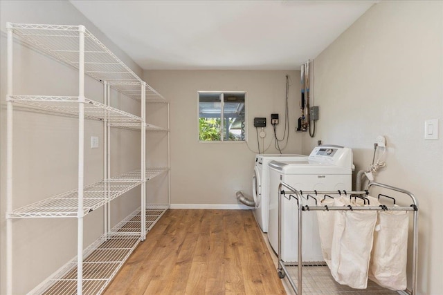 laundry room with light hardwood / wood-style flooring and washing machine and clothes dryer