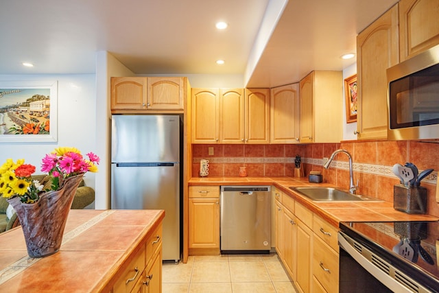 3559 Lower Honoapiilani Rd Unit 720, Lahaina, HI 96761 - kitchen with stainless steel appliances, tile countertops, a sink, light brown cabinetry, and decorative backsplash