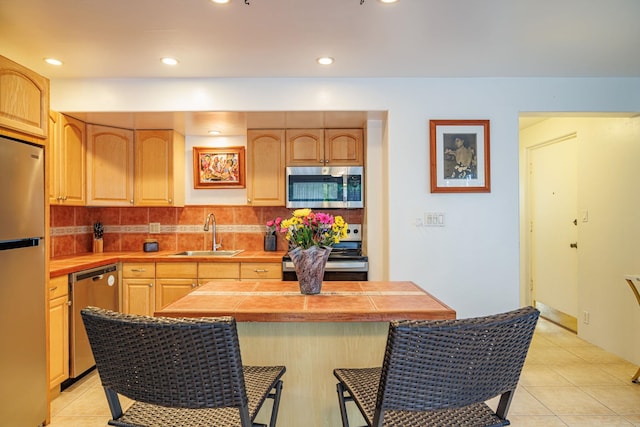 3559 Lower Honoapiilani Rd Unit 720, Lahaina, HI 96761 - kitchen featuring stainless steel appliances, a sink, tile countertops, a breakfast bar, and backsplash