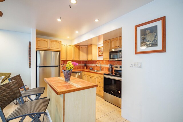 3559 Lower Honoapiilani Rd Unit 720, Lahaina, HI 96761 - kitchen featuring stainless steel appliances, light brown cabinets, a sink, a center island, and decorative backsplash