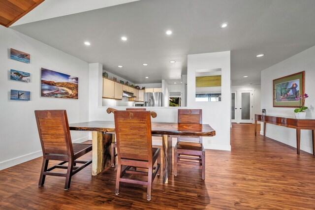 dining area featuring vaulted ceiling and dark hardwood / wood-style floors