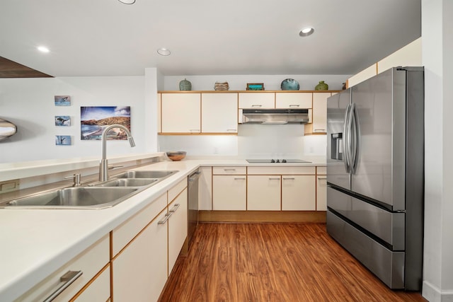 kitchen with light hardwood / wood-style floors, cream cabinets, stainless steel appliances, and sink