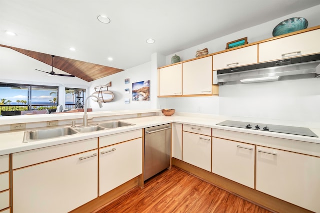 kitchen featuring lofted ceiling, black electric stovetop, sink, stainless steel dishwasher, and light hardwood / wood-style floors