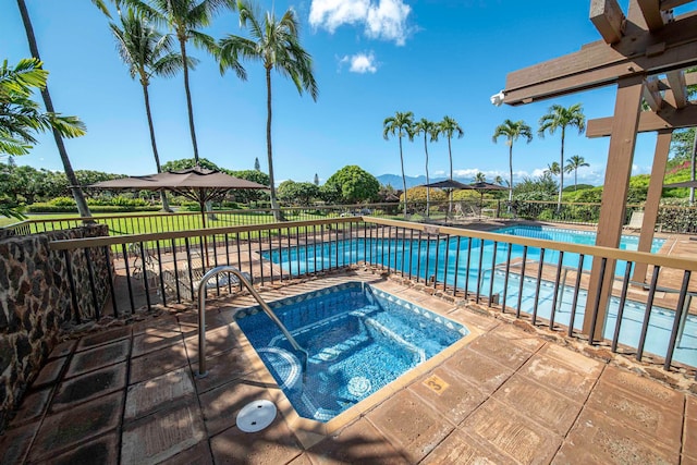 view of swimming pool with an in ground hot tub