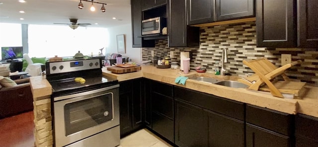 kitchen with sink, ceiling fan, dark brown cabinets, stainless steel appliances, and decorative backsplash