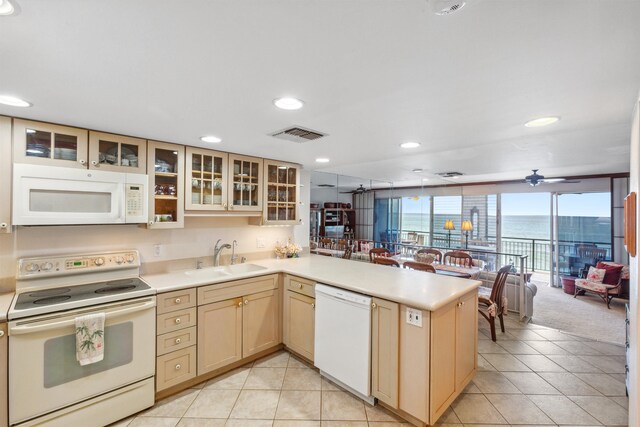 kitchen featuring ceiling fan, sink, kitchen peninsula, white appliances, and light tile patterned flooring