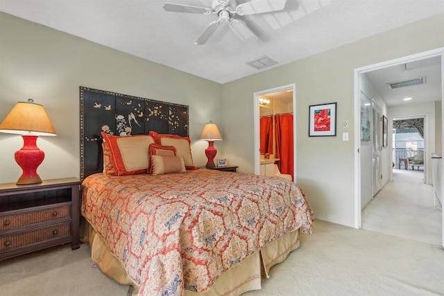 bedroom with connected bathroom, light carpet, and ceiling fan