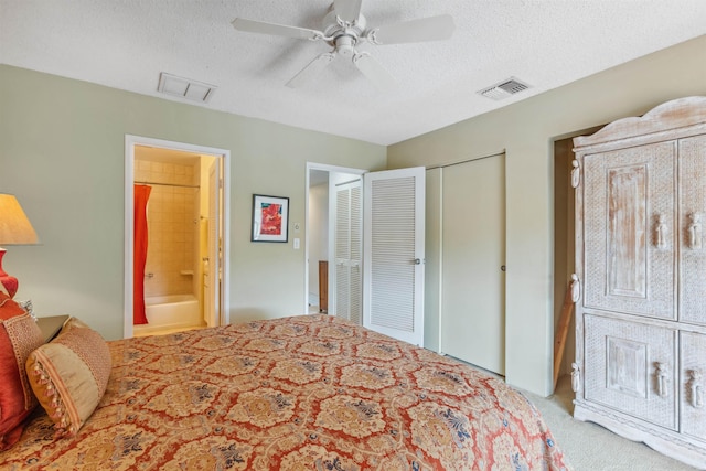 bedroom with connected bathroom, ceiling fan, light carpet, and a textured ceiling