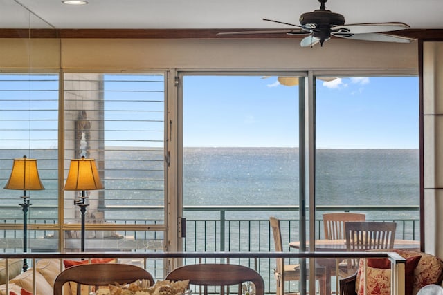 sunroom with a water view, a wealth of natural light, and ceiling fan