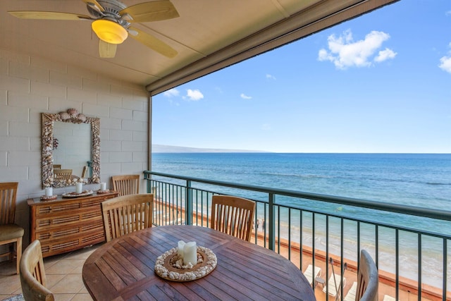 balcony featuring a view of the beach, a water view, and ceiling fan