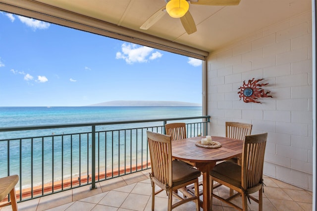 balcony featuring a view of the beach, a water view, and ceiling fan