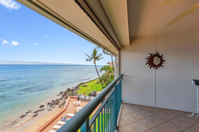 balcony with a water view and a view of the beach