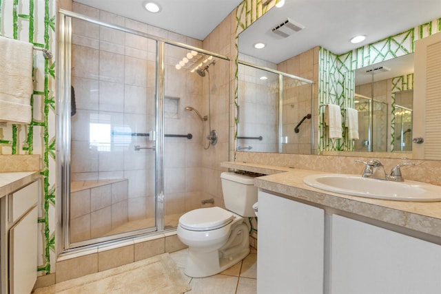 bathroom featuring tile patterned flooring, vanity, toilet, and a shower with shower door