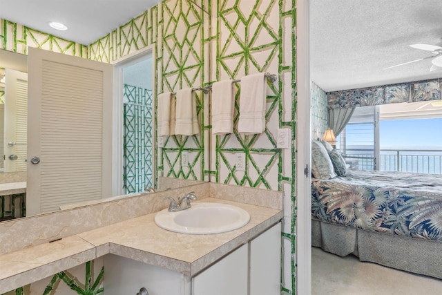 bathroom featuring a textured ceiling, vanity, and ceiling fan