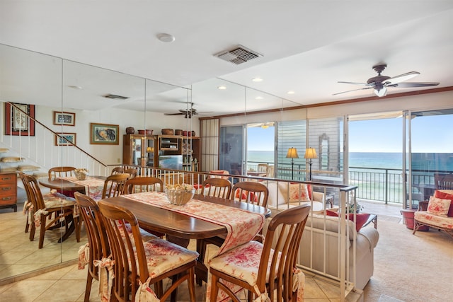 tiled dining room featuring a water view and ceiling fan