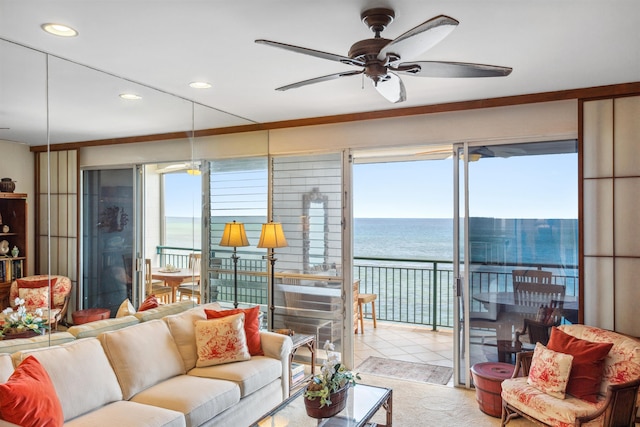 living room with ceiling fan, a water view, and light tile patterned floors