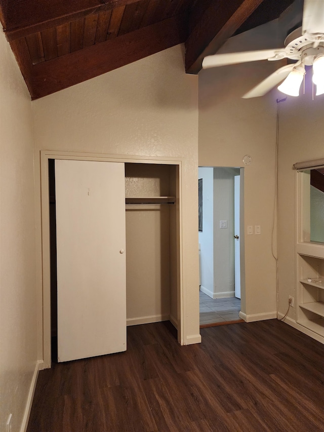 unfurnished bedroom featuring a closet, wooden ceiling, ceiling fan, vaulted ceiling with beams, and dark hardwood / wood-style floors