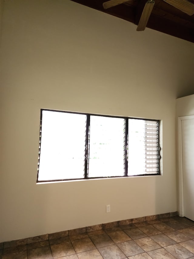 empty room with high vaulted ceiling, beam ceiling, and plenty of natural light