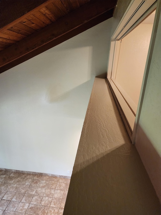 hallway featuring wooden ceiling, lofted ceiling with beams, and light tile patterned floors