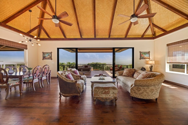 living room with dark hardwood / wood-style floors, beam ceiling, ceiling fan with notable chandelier, and high vaulted ceiling