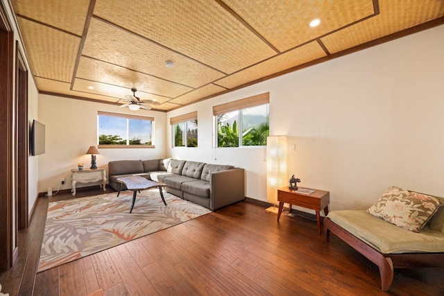 living room featuring wood-type flooring, ceiling fan, and crown molding