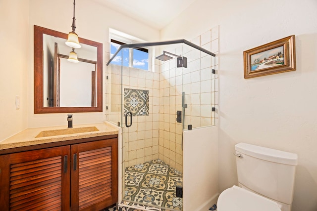 bathroom featuring vanity, toilet, and a shower with shower door