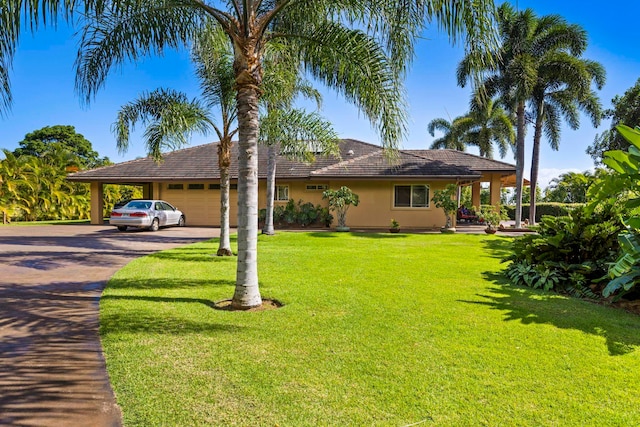 view of front of property with a carport, a garage, and a front lawn