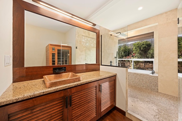 bathroom with hardwood / wood-style floors, vanity, and independent shower and bath