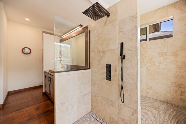 bathroom featuring hardwood / wood-style flooring, vanity, and tiled shower