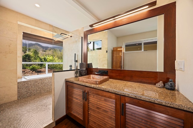 bathroom featuring vanity and a relaxing tiled tub