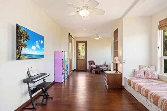 interior space featuring a barn door, ceiling fan, and dark wood-type flooring