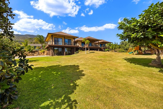 exterior space with a lawn, a mountain view, and a playground