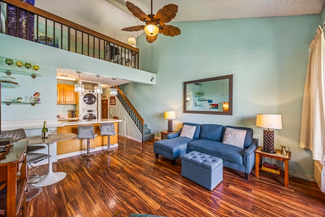 living room with high vaulted ceiling, ceiling fan, dark hardwood / wood-style floors, a textured ceiling, and stacked washer / drying machine