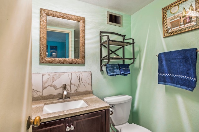 bathroom featuring backsplash, vanity, and toilet