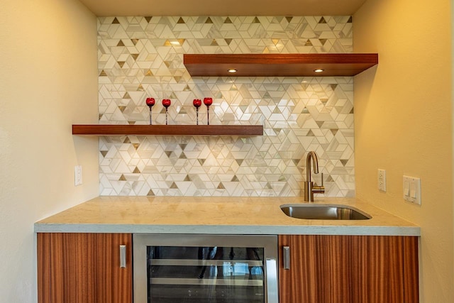 bar featuring backsplash, wet bar, a sink, and beverage cooler