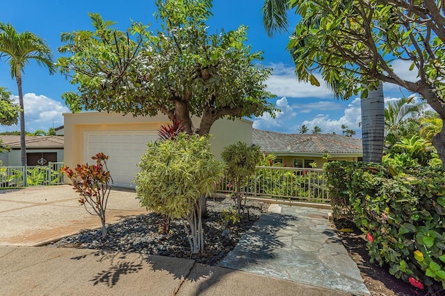 obstructed view of property featuring driveway, a tiled roof, fence, a garage, and stucco siding