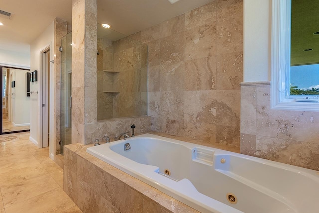 bathroom featuring a shower stall, tile walls, a jetted tub, and visible vents
