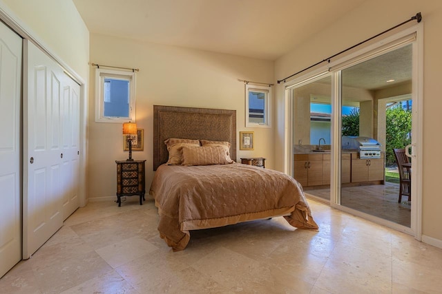 bedroom with access to outside, baseboards, and a sink
