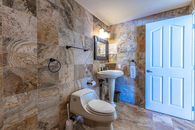 bathroom featuring tile walls and toilet