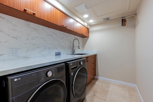 clothes washing area featuring separate washer and dryer, visible vents, baseboards, and a sink