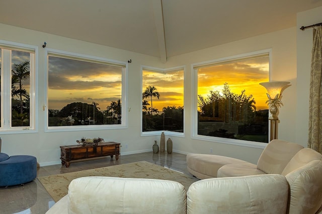 sitting room featuring vaulted ceiling and baseboards