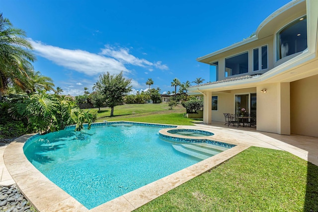 view of pool with a patio area, a pool with connected hot tub, and a lawn