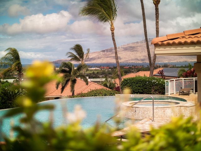 view of swimming pool with a mountain view and a community hot tub