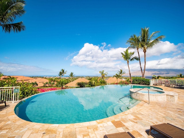 view of swimming pool featuring a patio area, an in ground hot tub, and a mountain view