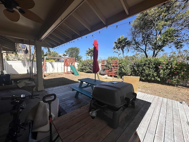 deck featuring ceiling fan, area for grilling, and a playground