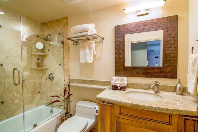 full bathroom featuring vanity, combined bath / shower with glass door, and toilet